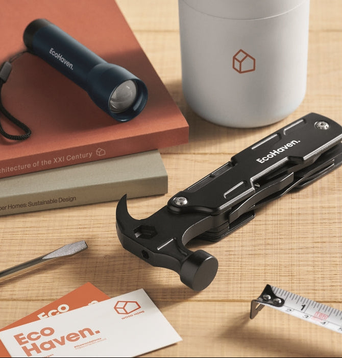 custom printed multi-tool with hammer head on a wooden surface with books, flashlight, and mug in the background.