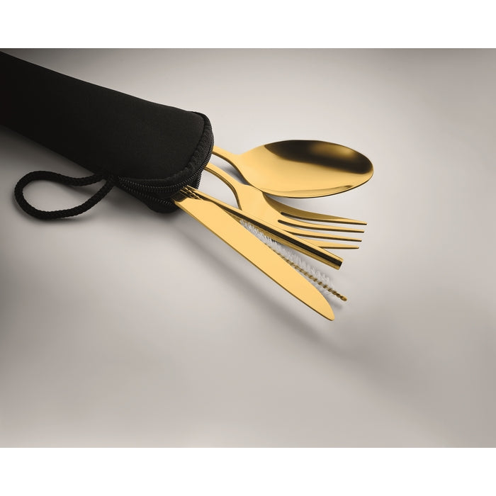 Gold cutlery set with black pouch on a gray background