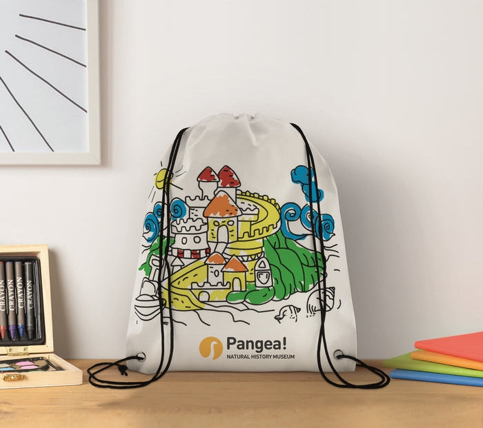 A white drawstring gym bag featuring a colorful line art illustration of a castle and the Pangea! logo, displayed on a wooden desk against a white wall.