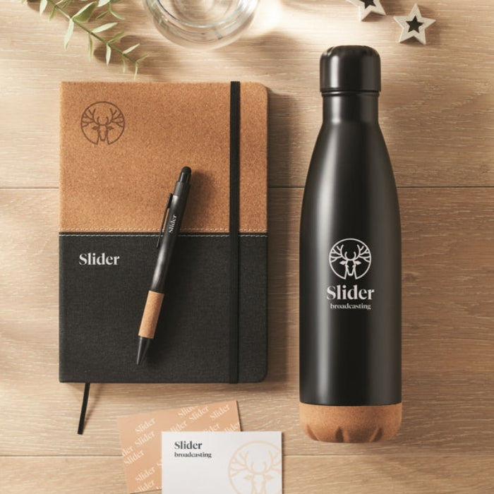 Black water bottle, notebook, pen, and business cards on a wooden surface with 'Slider' branding.